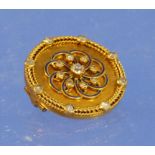 A circular yellow metal Brooch with rope work rim set with eight small diamonds, the centre set with