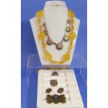 A long Necklace of yellow plastic roundels with twisted rectangular links between, hook clasp and