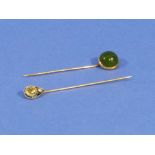 Two Stickpins one set in yellow metal, the finial half cabouchon jadeite, the other with yellow