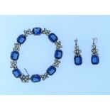 A bracelet and matching Earrings, mounted in white metal, the bracelet with eight facetted blue