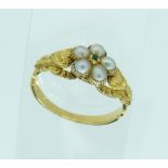 A small antique Ring, the front set with five seed pearls and centre small emerald, carved shoulders