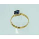 A 22ct yellow gold Ring, in square mount with a small calibre cut sapphire, Size M.
