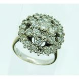 An 18ct white gold Ring, the front set with an open circle of eighteen diamonds, the centre with a