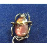 An amusing Brooch, in the form of a large bug, the gilt metal body foil set in pink and yellow, 1½in