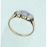 A yellow metal Ring, set with three graduated cabochon opals, Size N.