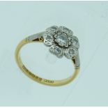 A Ring, the front set with a diamond surrounded by six petals each set with small diamond, mounted