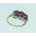 A three stone ruby Ring, the oval stone surrounded by small diamonds, mounted in 9ct yellow gold and