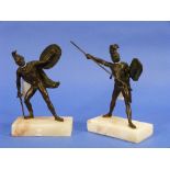 A pair of 19thC bronze figures of Greek warriors, with helmets, shields and weapons, on