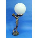 An Art Deco grey/silver spelter Goddess of Light Table Lamp, the female nude holding a white glass