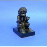 A 19thC French bronze Faun, seated and blowing through his hands, on rectangular polished black