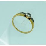 A small sing stone diamond Ring, in rubbed-over mount, with two diamond points on each shoulder,