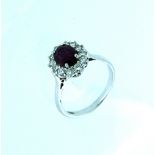 A ruby and diamond cluster Ring, mounted in 18ct white gold and platinum, the oval centre stone
