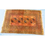 Tribal Rugs; an orange ground Afghan rug, with four central tekke within a wide geometric border,