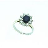 A sapphire and diamond cluster Ring, mounted in white gold and platinum, the central oval stone