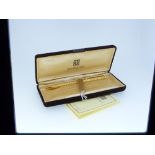 Givenchy; a gold-plated retractable ball-point pen, 5¼in (13.25cm) long, cased with instruction