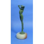 An Art Deco green patinated bronze figure of a nude, she standing with arms on head, on circular