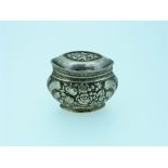 An antique German silver Pill Box, marked "800", of hinged oval form, chased with floral decoration,