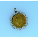 A George V gold Sovereign, dated 1913, in 9ct gold scroll-work mount with suspension loop. THIS