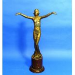 An Art Deco gilded spelter figure, she standing in a long skirt and top with her arms