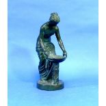 An early 20thC green patinated bronze figure of a semi-clad woman, she standing and holding a two-