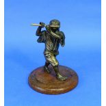 A 19thC oriental bronze figure, of a boy playing the flute, on circular wood base, signed, overall