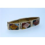 A Scottish pebble hinged six plaque Bracelet, each plaque mounted in engraved gilt metal and each