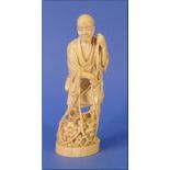 A 19thC Japanese carved ivory figure of a Labourer, standing with vegetables in a net, on circular