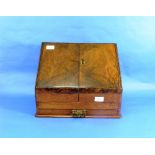 An early 20thC walnut Stationery Box, the fall-front enclosing a fitted interior and two ink pots,