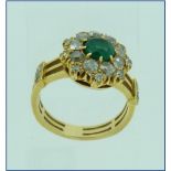 An emerald and diamond cluster Ring, the central emerald surrounded by nine diamonds, with a further