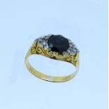 An 18ct yellow gold Ring, mounted with an oval sapphire, c.1¼ct., with three diamond points on the