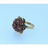 A 18ct yellow gold and ruby Ring, the front mounted with pale rubies surrounded with double leaf