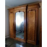 A Victorian walnut breakfront Wardrobe, with central mirrored door, 84in (213.5cm) wide. Provenance: