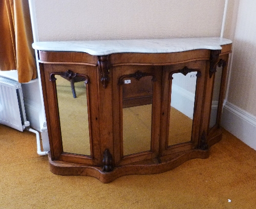 A Victorian walnut Credenza, with marbled top and mirrored doors, 60in (152.5cm) wide. Provenance: