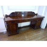 An early 19thC mahogany pedestal Sideboard, with carved decoration, 96in (244cm) wide. Provenance: