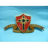 Les Filles de la Croix: a carved wooden plaque of the Les Filled de la Croix crest, formed of a