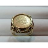 A gold Ring, with fancy scroll mount, enclosing John. F. Kennedy commemorative coin, the mount