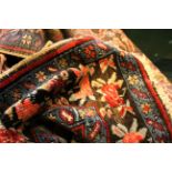 An antique Persian carpet, decorated with geometric designs on a tobacco field in shades of blue,