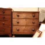 A Victorian mahogany chest of three long drawers, on bun feet.