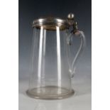 A clear glass tankard, fitted with later addition of 18th Century white metal lid, 23cm.