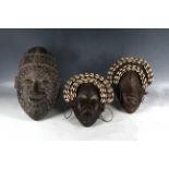 A pair of African carved wooden 'Dan' masks, and another carved wooden mask. (3)