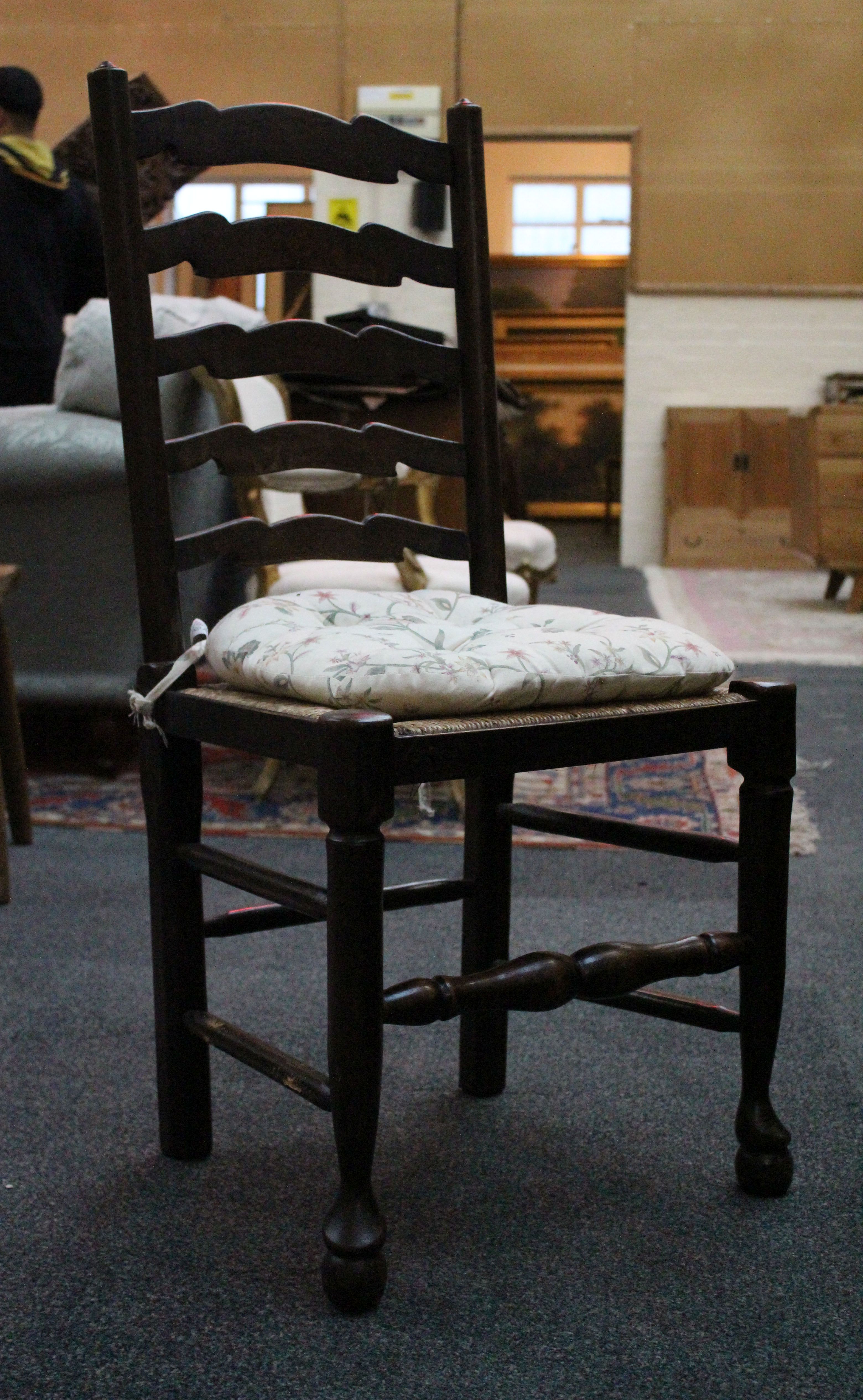 A set of eight ladder-back chairs, including two carvers, supported on pad feet. (8)