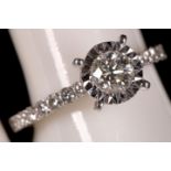 An 18ct white gold and diamond solitaire ring, with diamond shoulders, 0.86pts total.