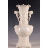 A Chinese cream vase, all over decoration, fluted rim, dog of Fo and loop ring handles, character