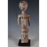 A carved African tribal figure, female fertility with black and red organic kaolin pigment, possibly