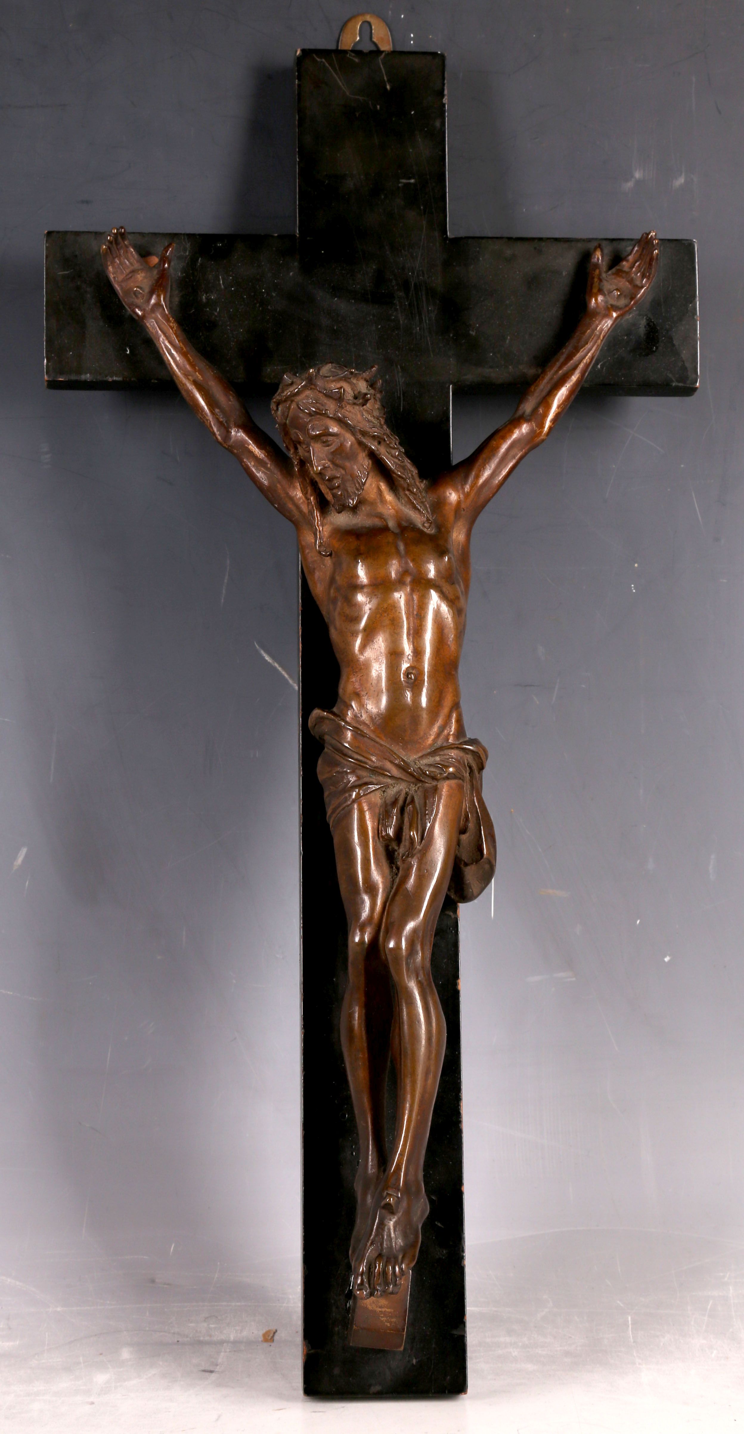 A late 19th Century bronze crucifix, the bronze corpus on an ebonised fruit wood cross, 40 x 20cm.
