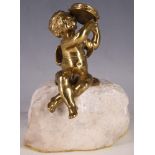 A late 19th Century solid brass statue of a child with tambourine, raised on a rough hewn quartz