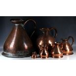 Seven copper measuring jugs.