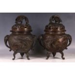 A pair of Japanese bronze incense burners, the body of each decorated with two panels with a pair of