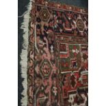 A large antique Hamadan rug, with circular medallions within broad frieze border in shades of