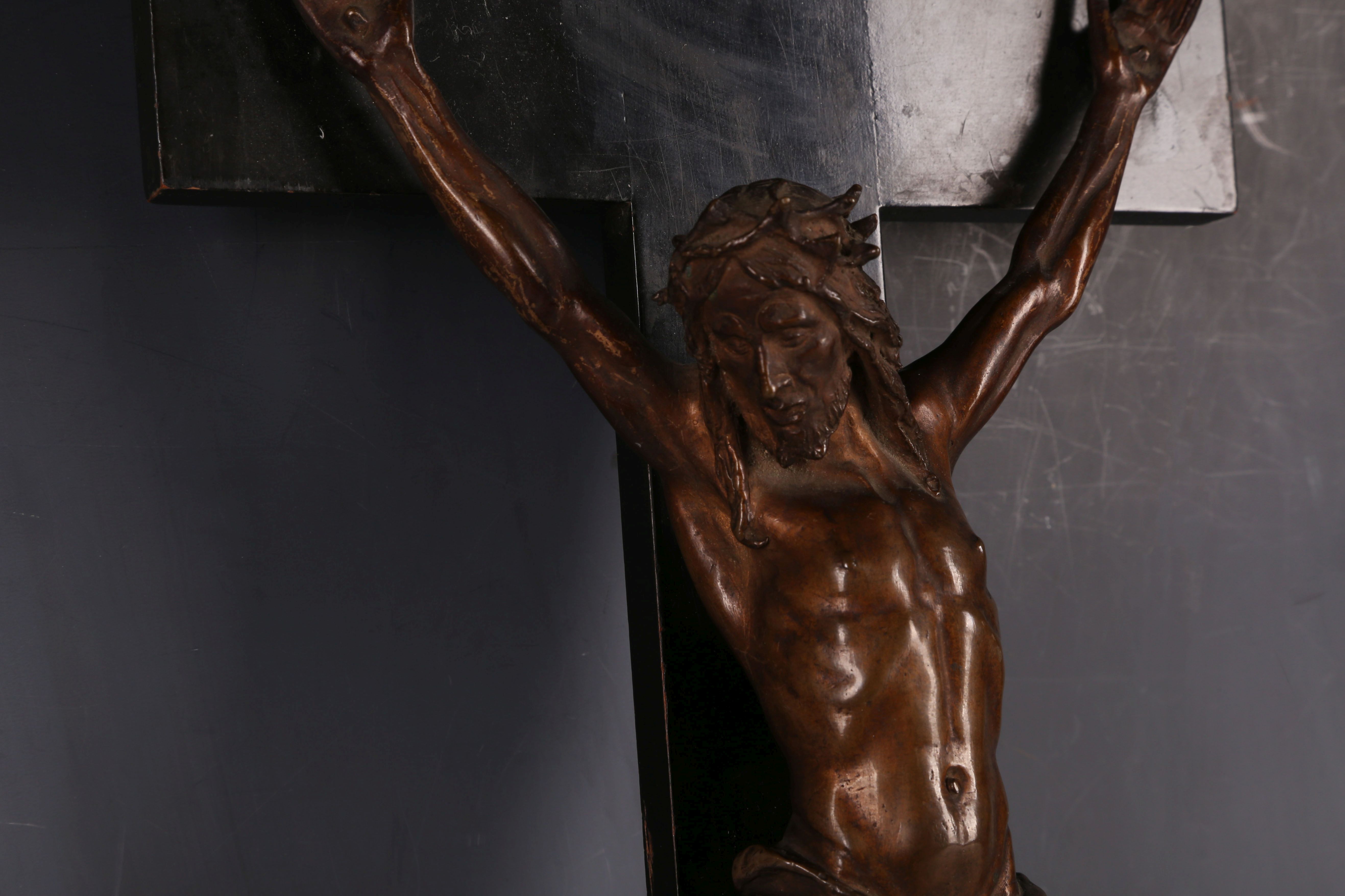 A late 19th Century bronze crucifix, the bronze corpus on an ebonised fruit wood cross, 40 x 20cm. - Image 3 of 3